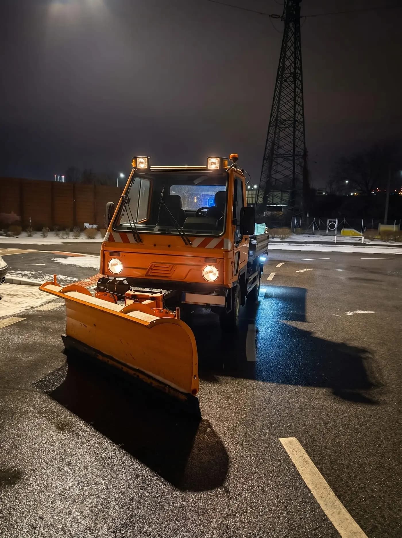 Multicar s radlicou pri nočnej zimnej pohotovosti v meste
